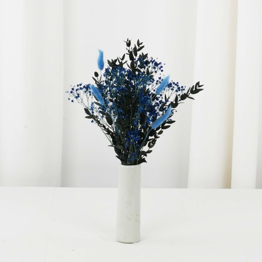 Torkad blomsterbordsdekoration i blå och gröna färger