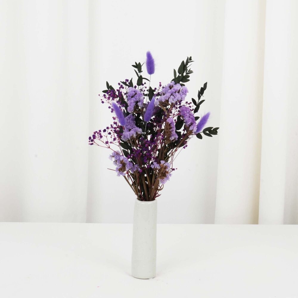 Torkad blomsterbordsdekoration i lila färger