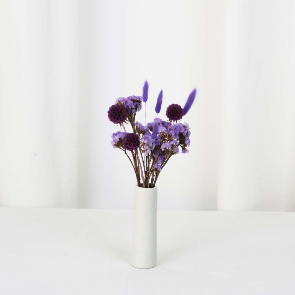Liten torkad blomsterbordsdekoration med scabiosa