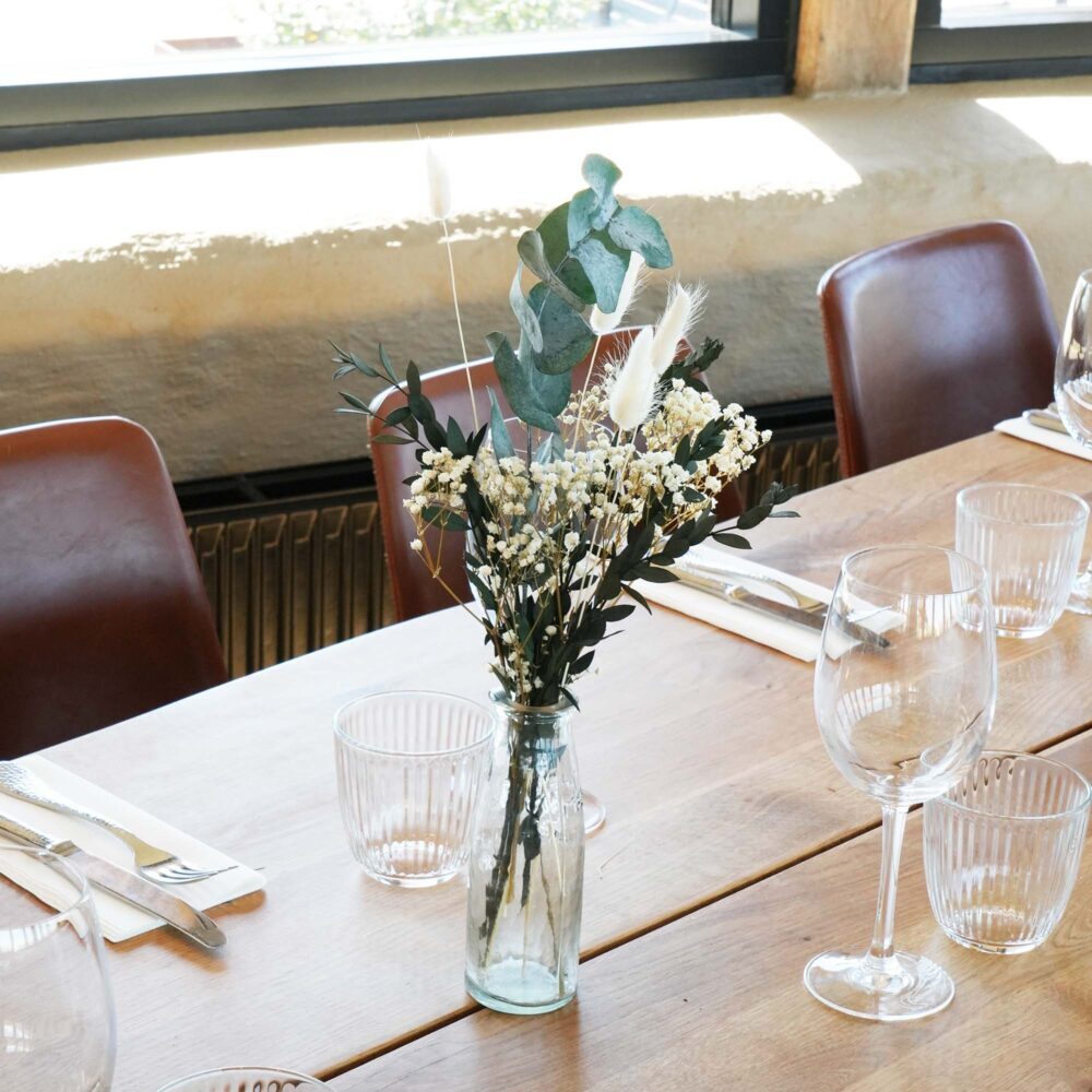 Torkad blomsterbordsdekoration i neutrala vita och gröna färger
